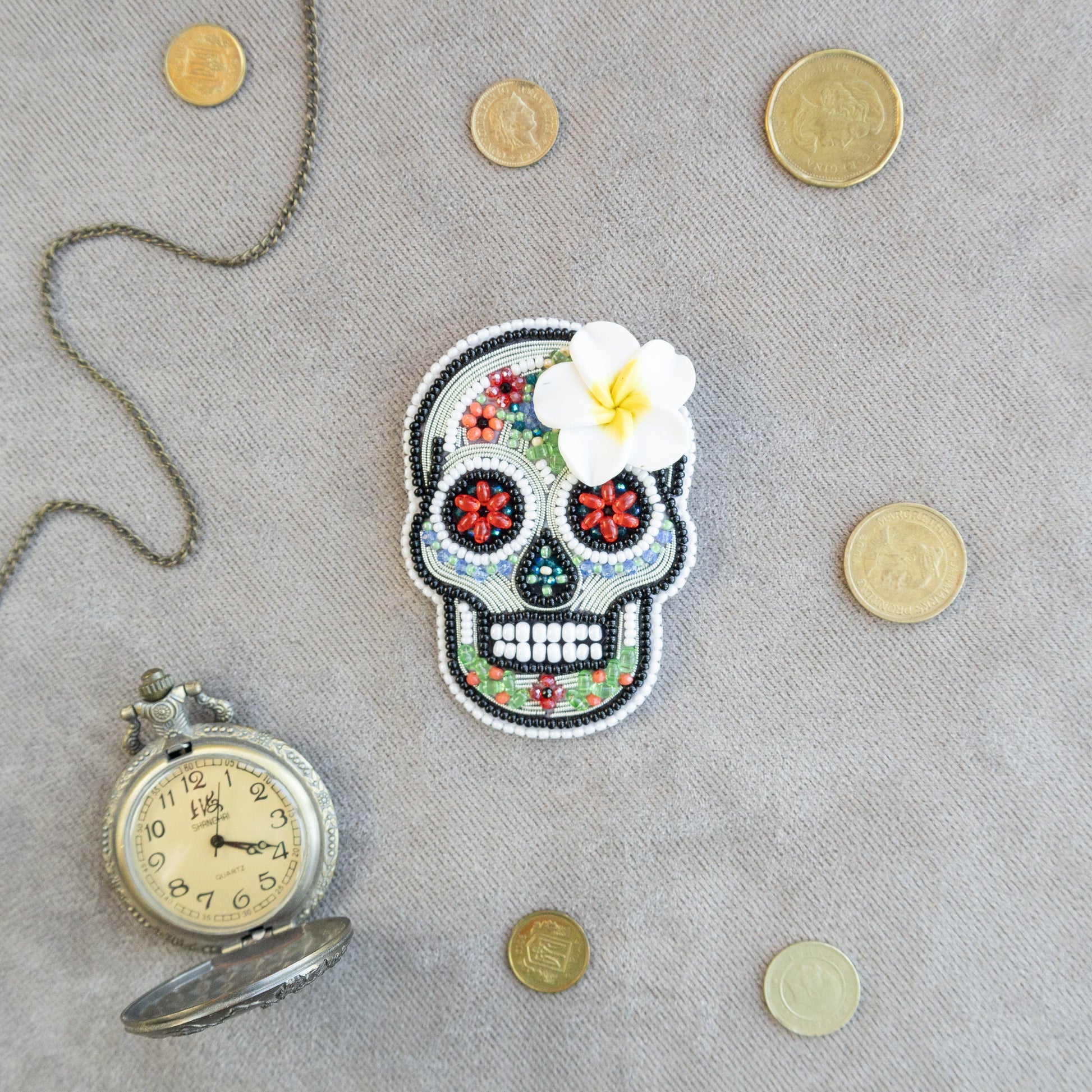 a picture of a skull with a flower and a pocket watch