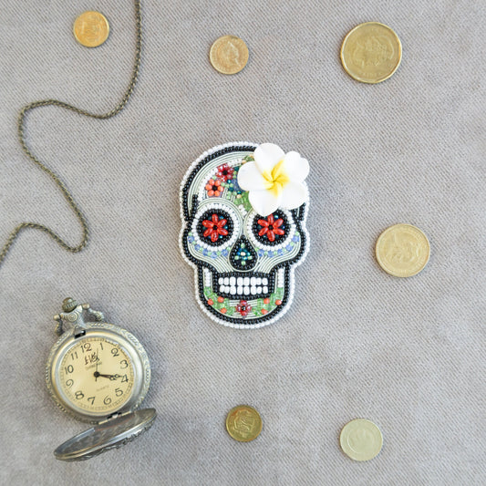 a picture of a skull with a flower and a pocket watch