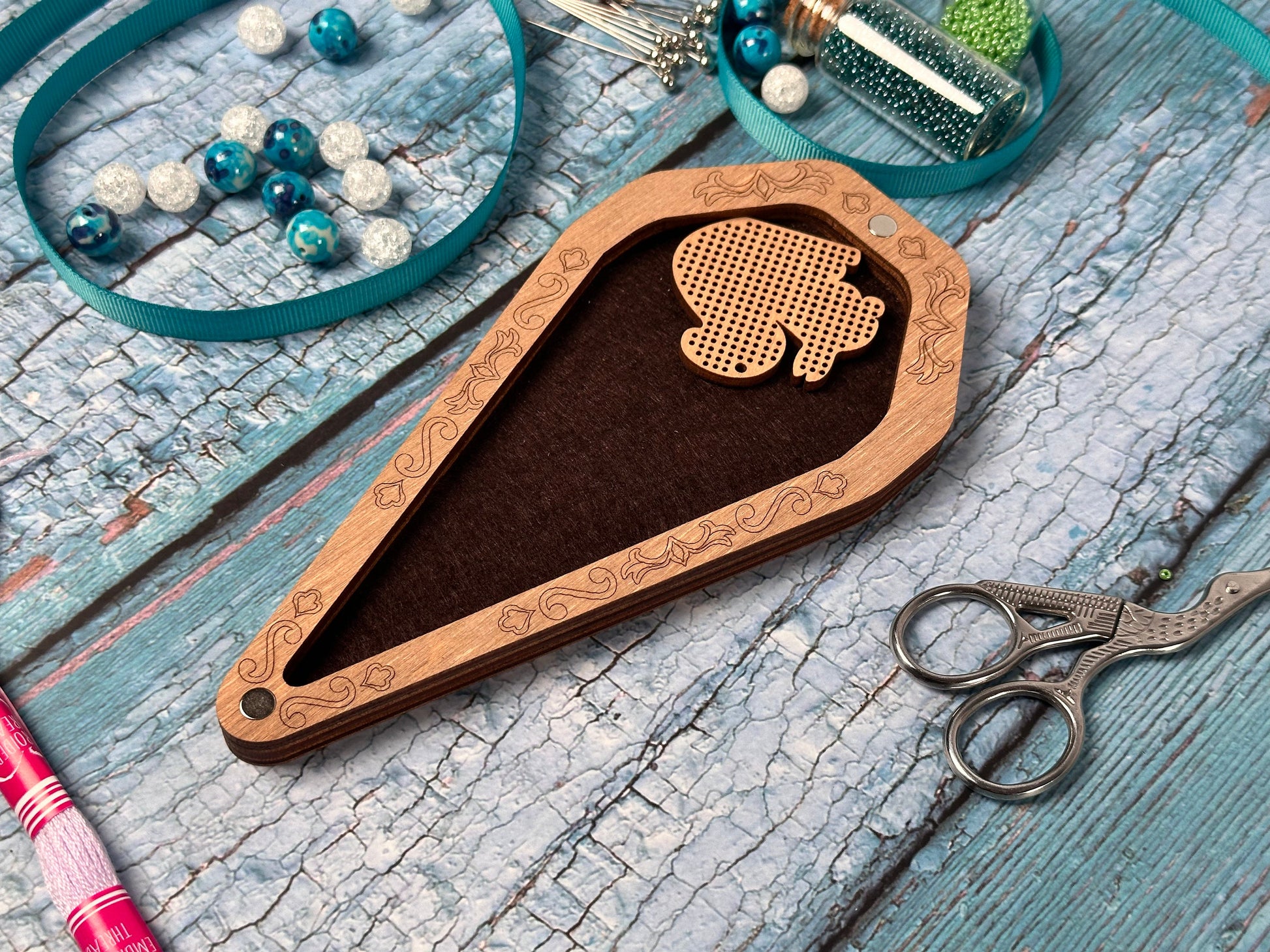 a pair of scissors and some beads on a table