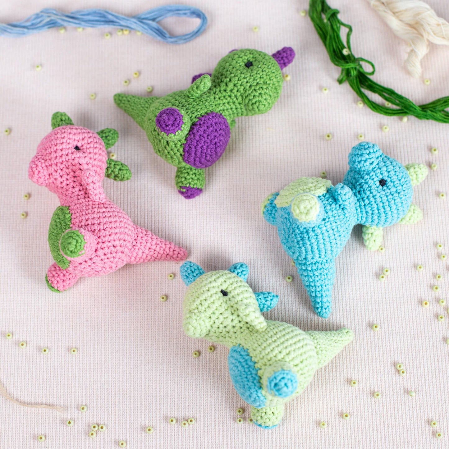 a crocheted blue and green stuffed animal sitting on a table