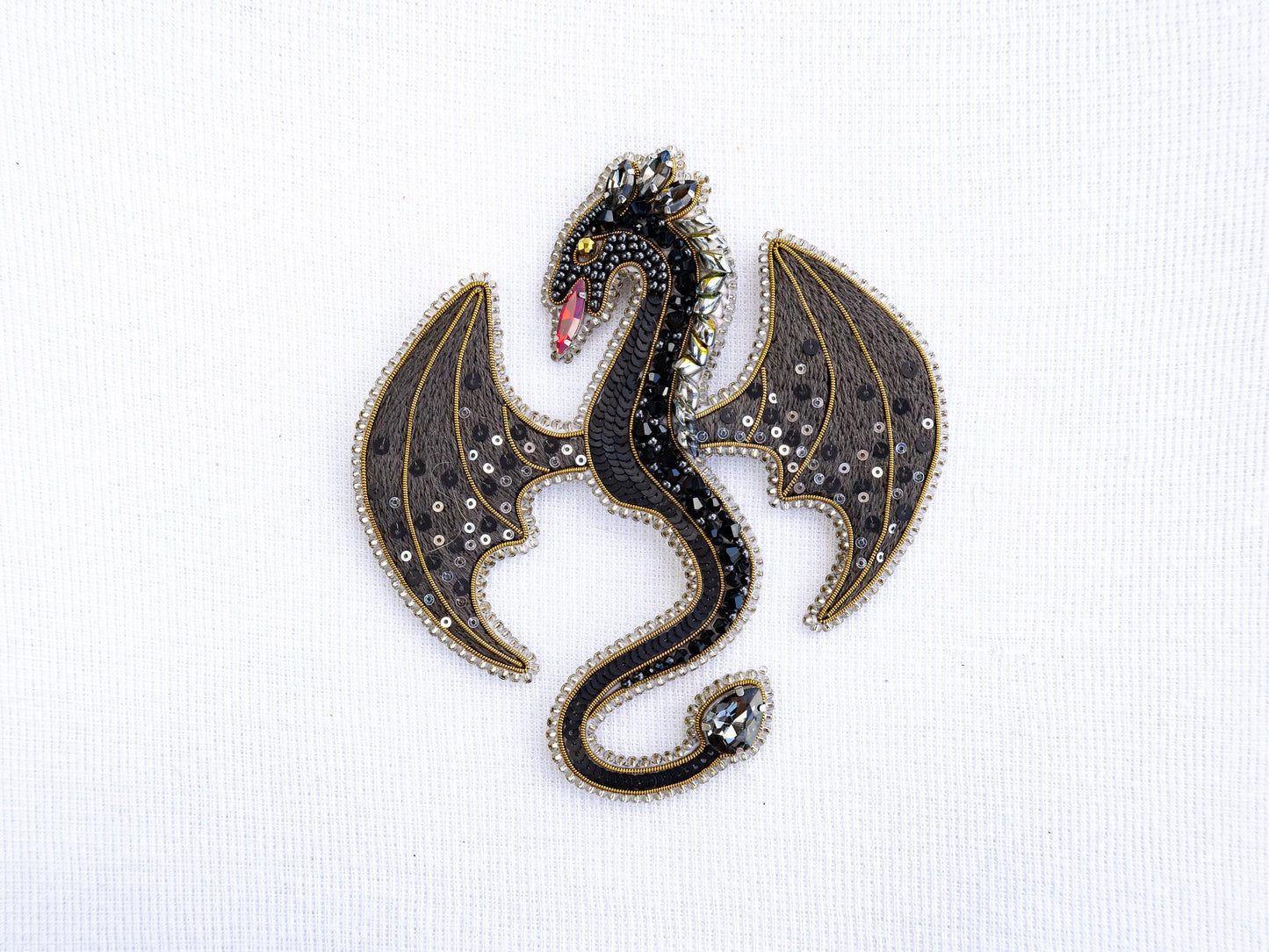 a brooch with a black dragon on it