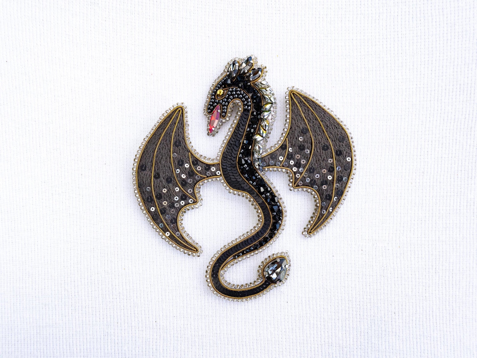 a brooch with a black dragon on it