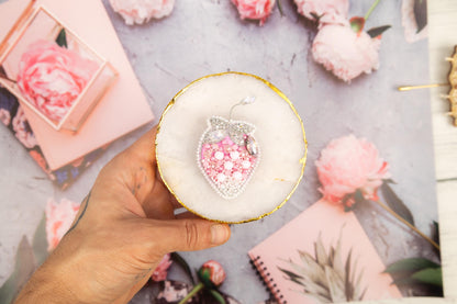 a person holding a piece of jewelry in their hand