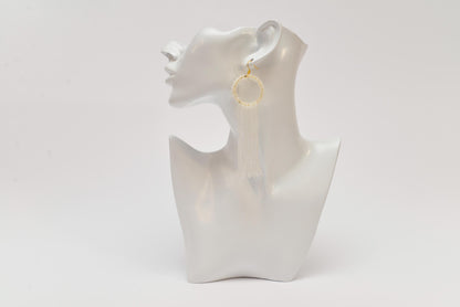 a white mannequin with a pair of earrings on it