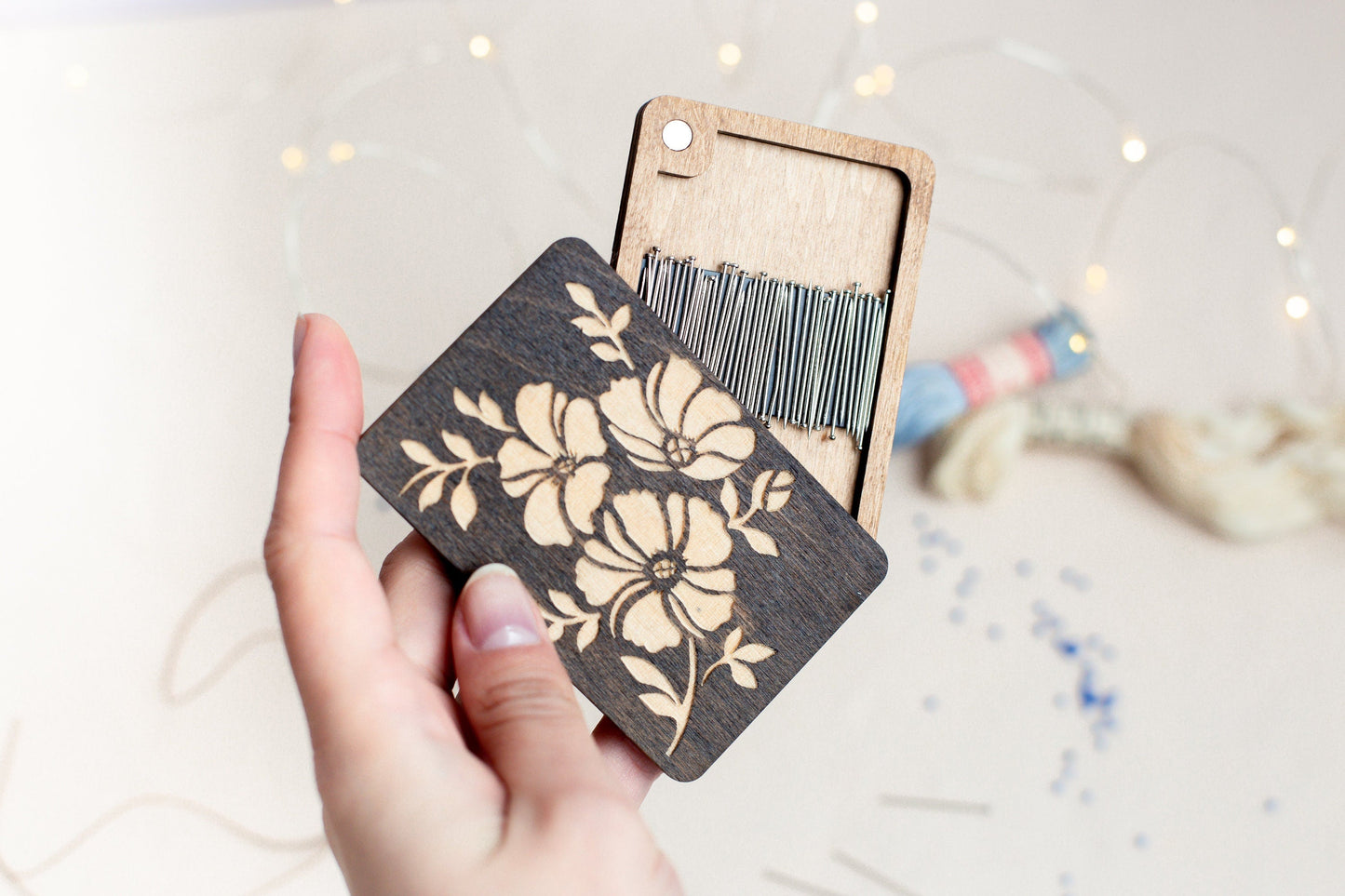 a person holding a piece of wood with a flower design on it