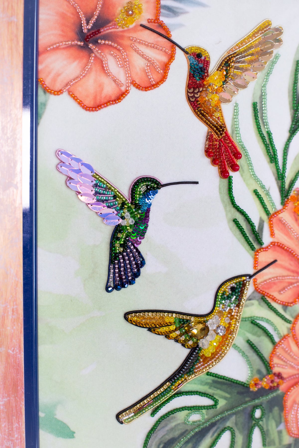 three colorful hummingbirds, each with distinct patterns and colors, against a backdrop of vibrant flowers and foliage.