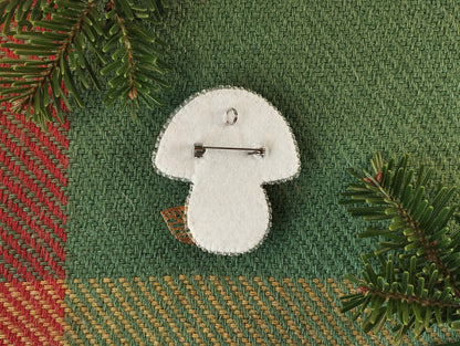 a white brooch with a pin on it