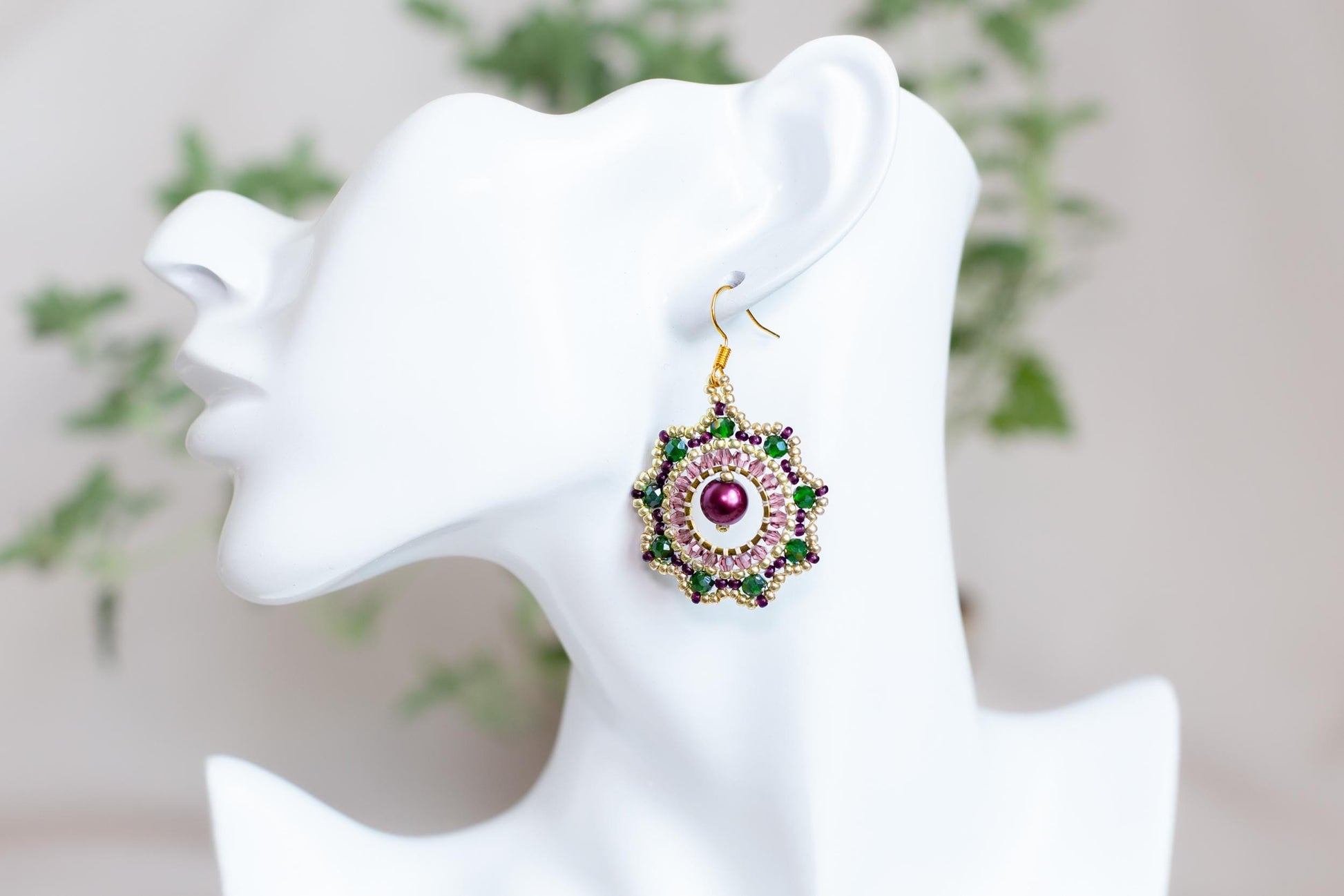 a close up of a pair of earrings on a mannequin head