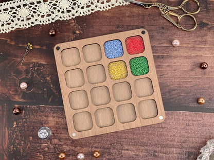 a wooden tray with beads and a pair of scissors