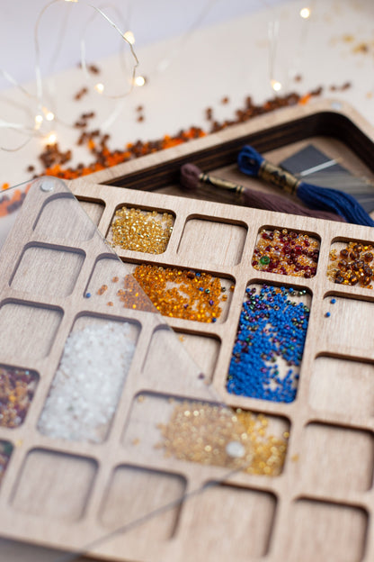 a wooden tray filled with lots of different colored beads