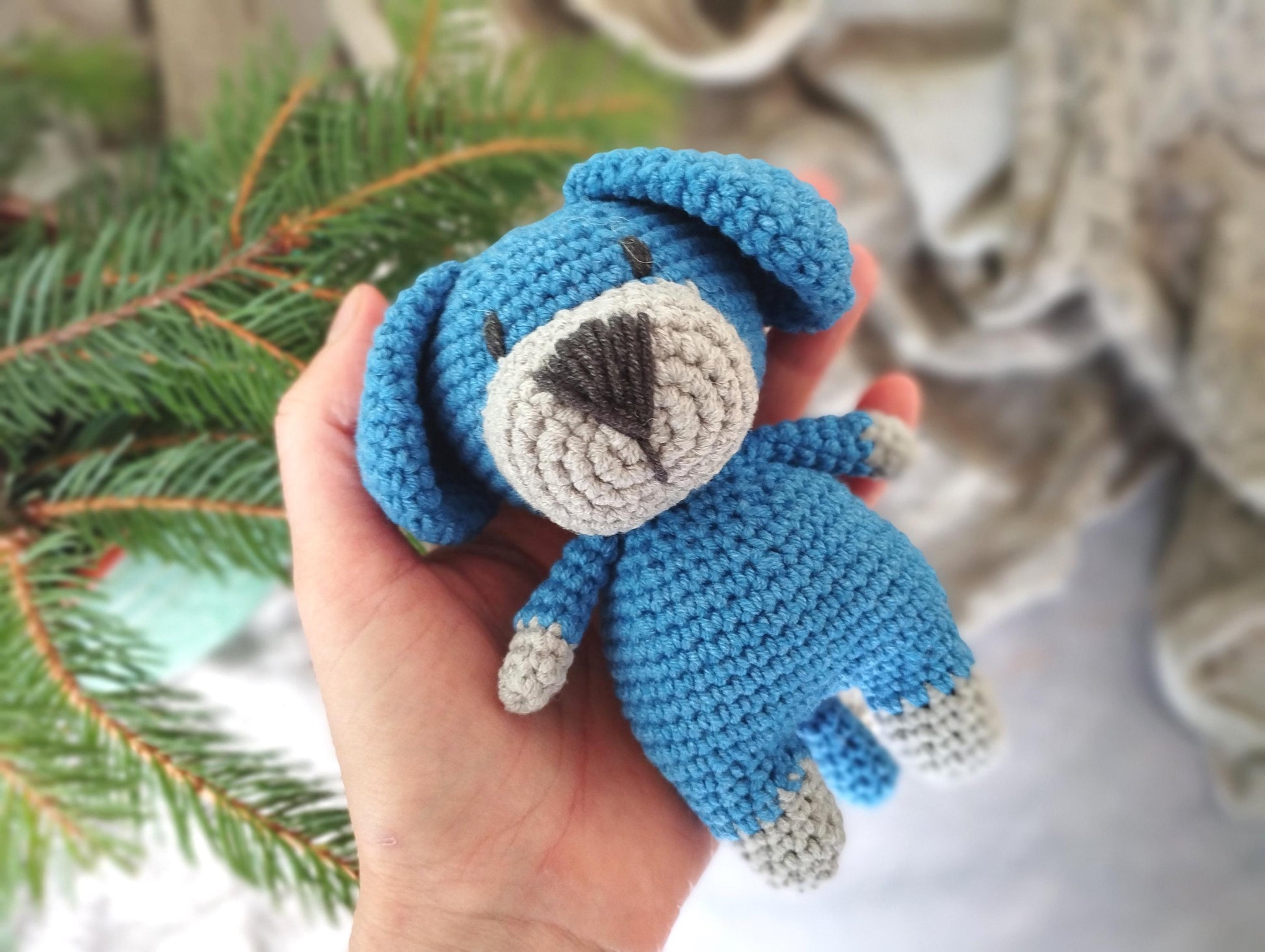 a hand holding a small crocheted stuffed animal