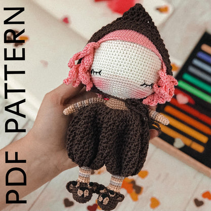a crocheted doll is held in a persons hand