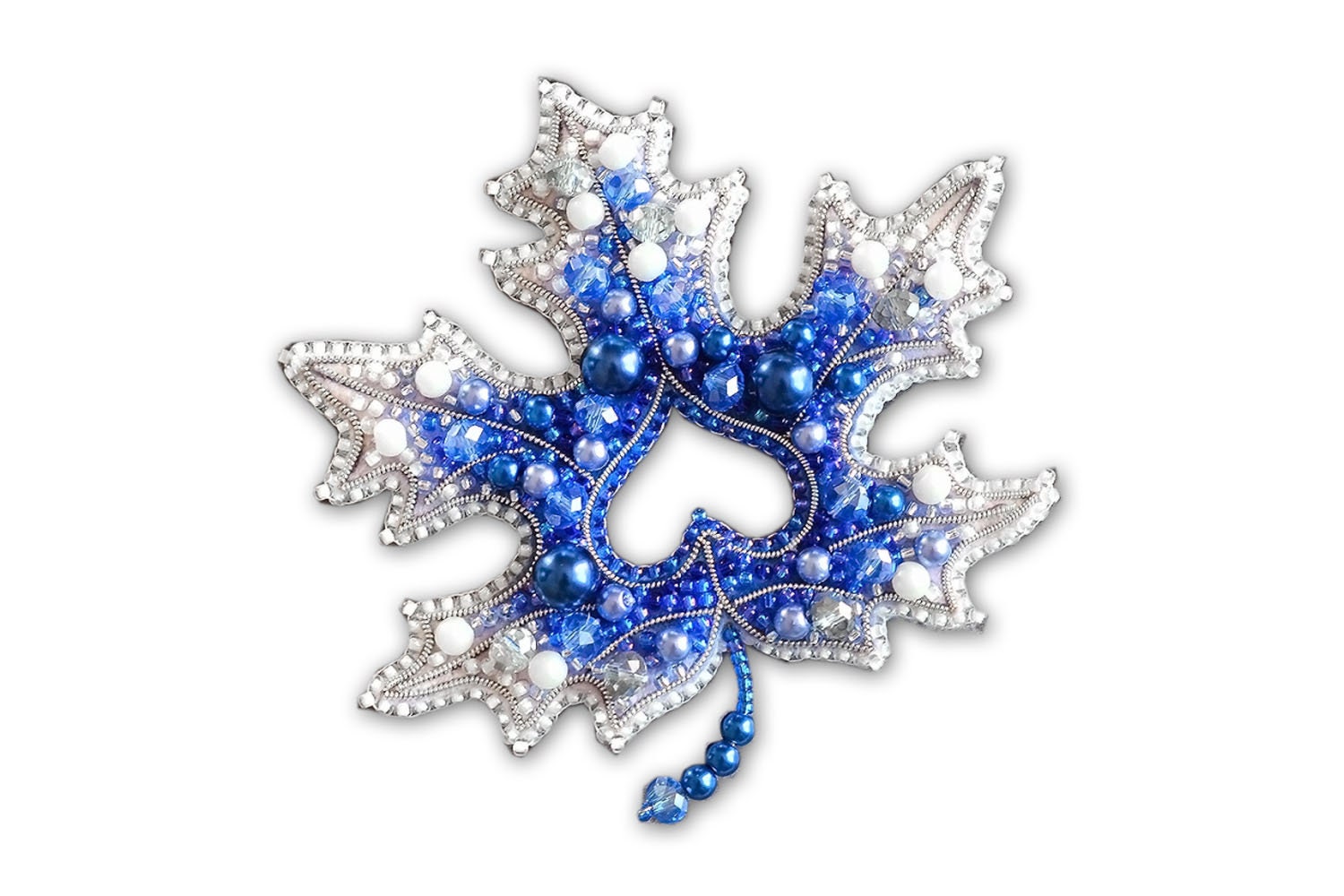 a blue and white brooch with beads on it