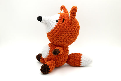 a knitted stuffed animal sitting on a white surface