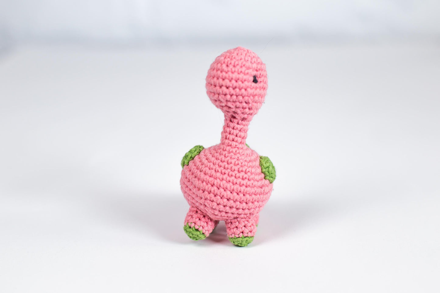a pink crocheted turtle sitting on top of a white table