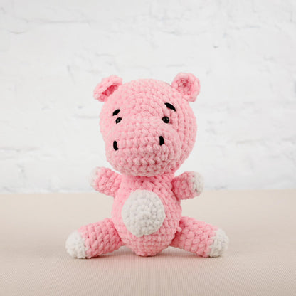 a pink crocheted stuffed animal sitting on a table