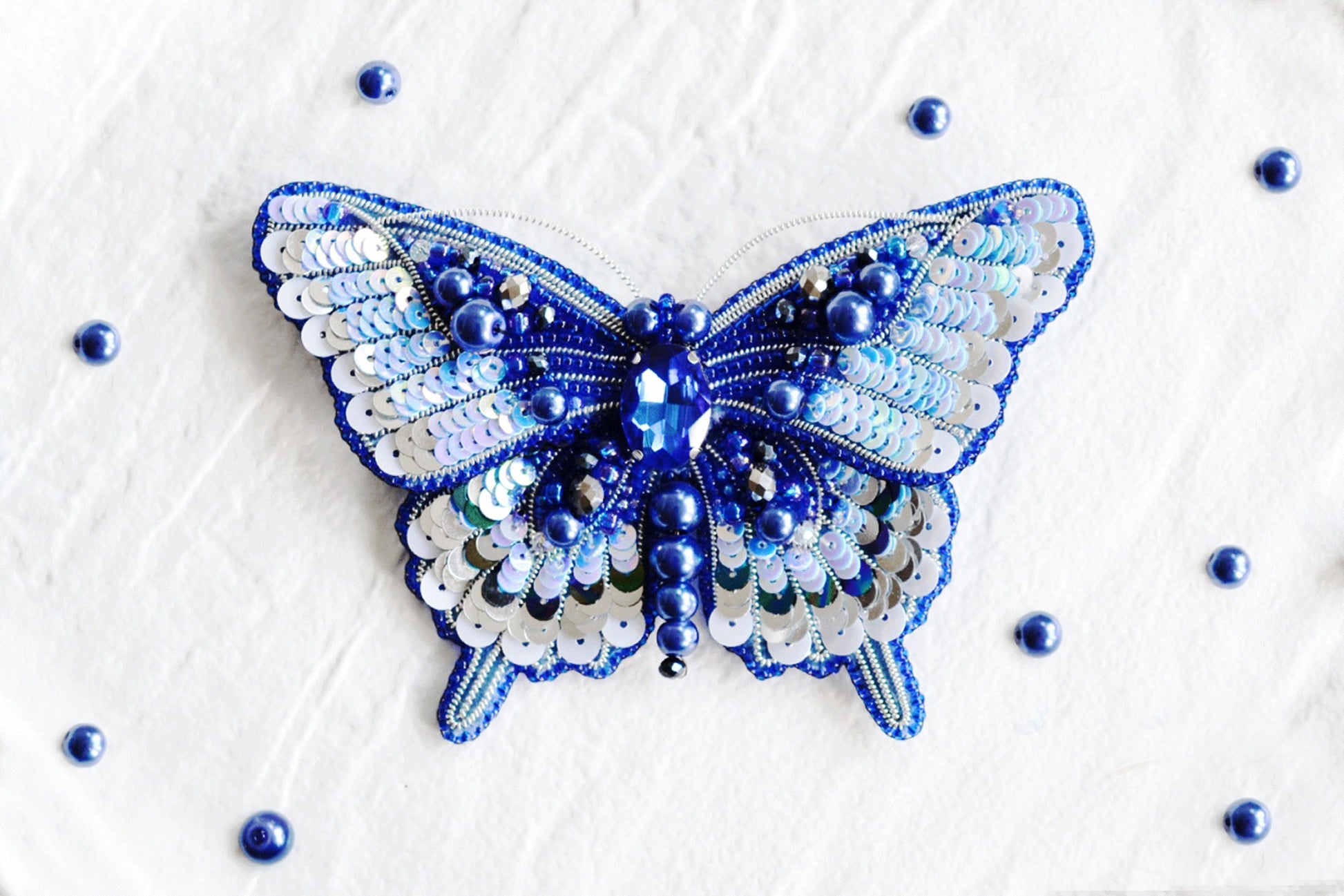 a blue and white butterfly made out of sequins