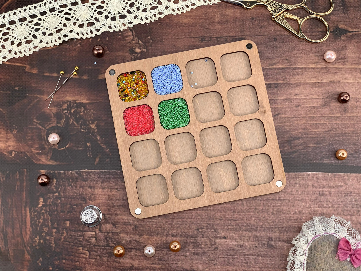 a box of beads next to a pair of scissors