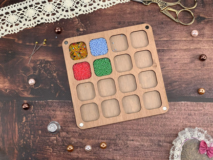 a box of beads next to a pair of scissors