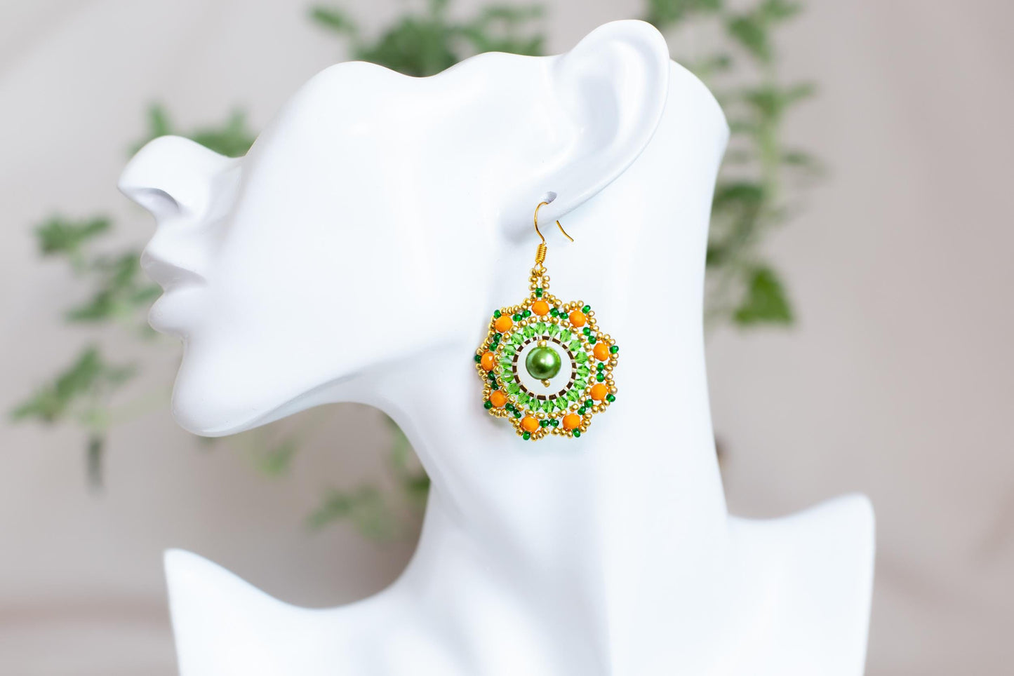 a close up of a pair of earrings on a mannequin head