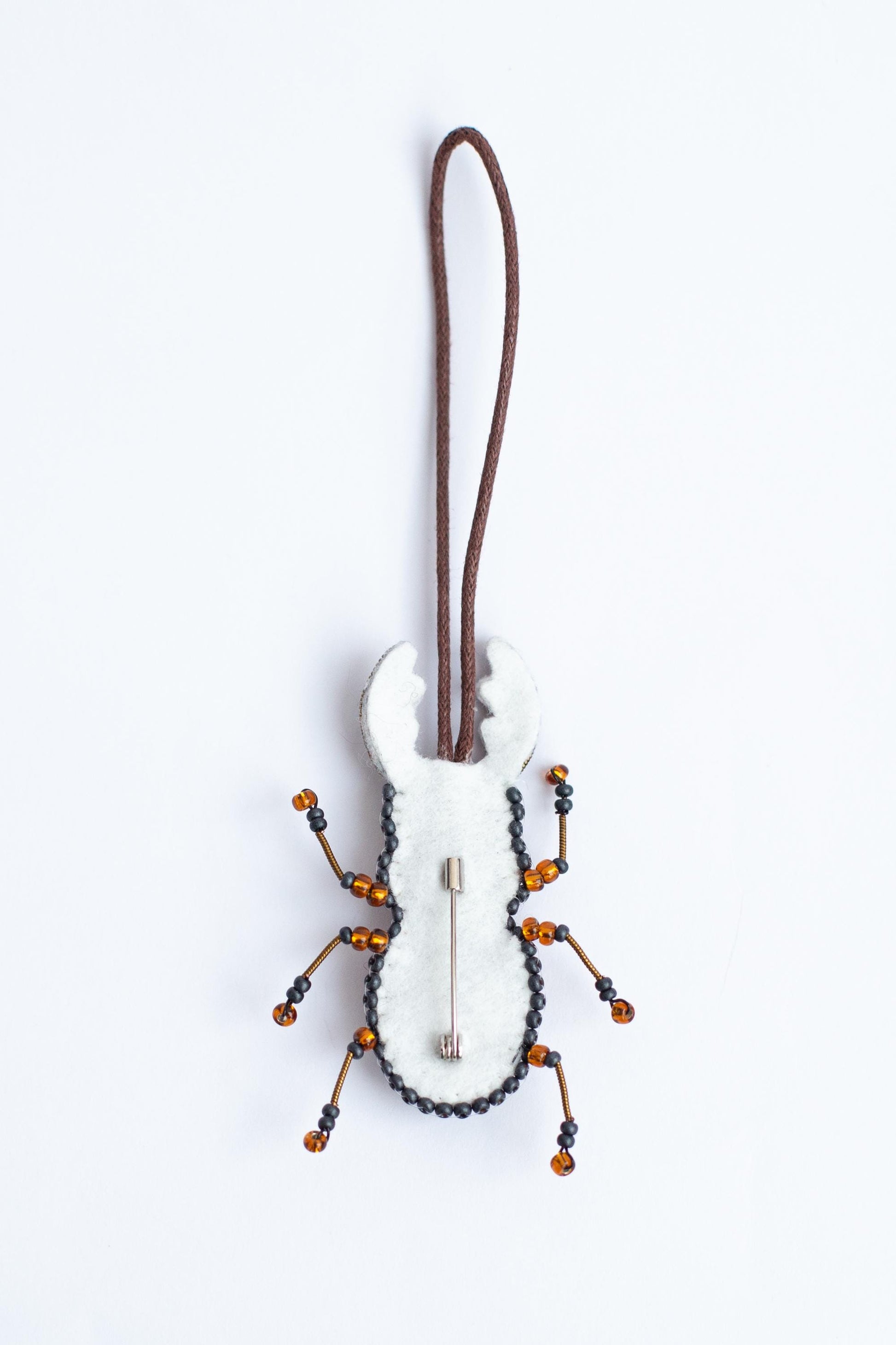 a white and black bug ornament hanging from a cord