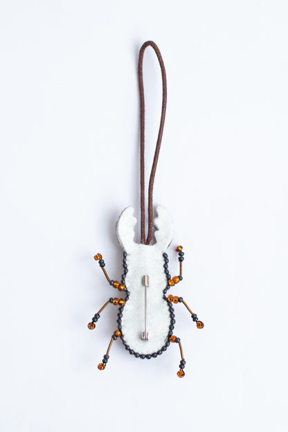 a white and black bug ornament hanging from a cord