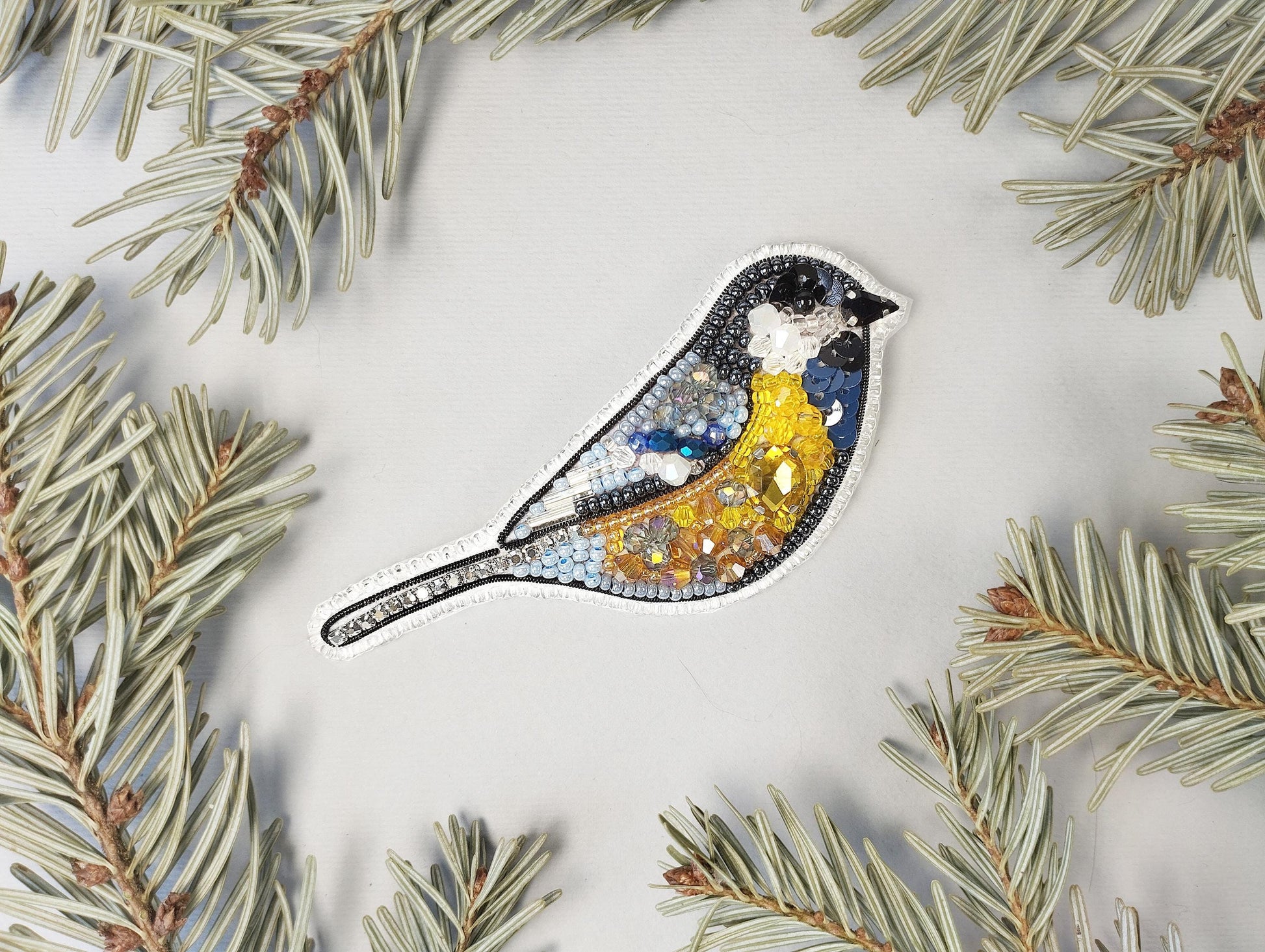 a blue bird sitting on top of a pine tree