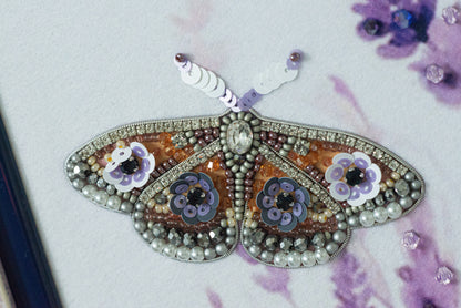 a detailed and intricate butterfly-shaped embroidery piece, adorned with various beads, sequins, and flowers.