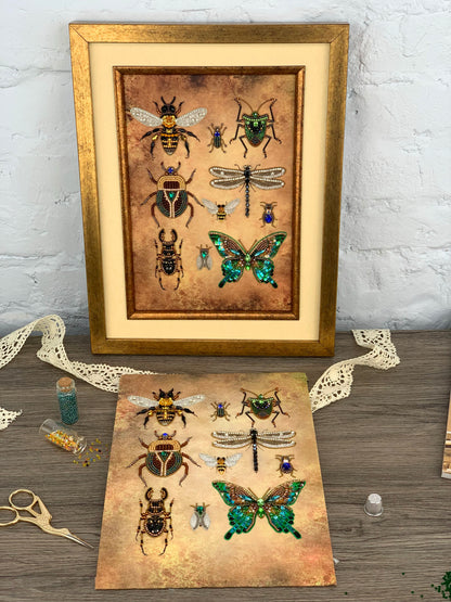 a framed print of various insects, including bees, butterflies, and dragonflies, along with some crafting supplies and materials on a wooden surface.