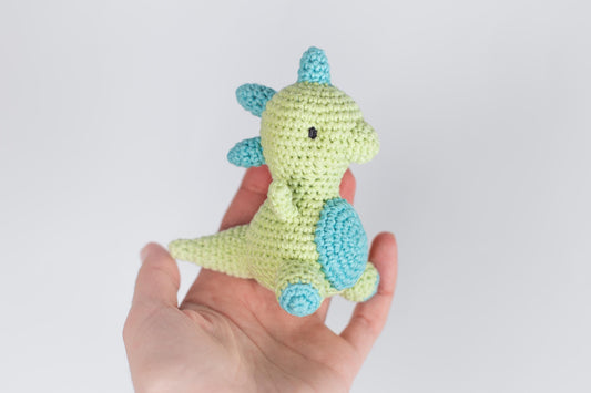 a hand holding a small crocheted toy in it&#39;s palm