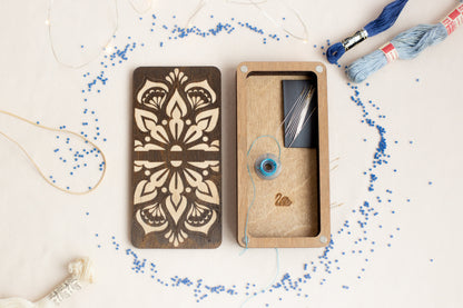 a pair of scissors and a box of thread on a table