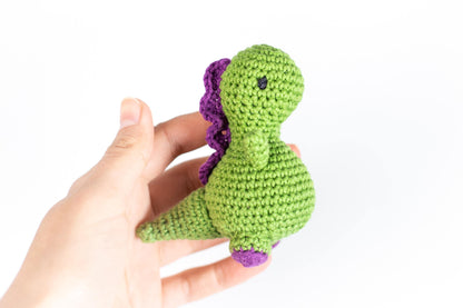a hand holding a small crocheted stuffed animal