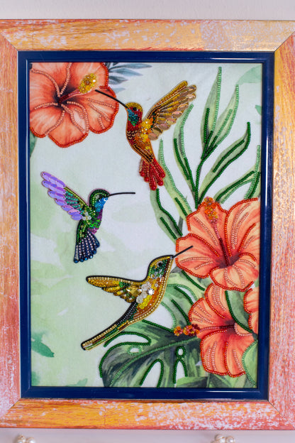 a vibrant and colorful painting of three hummingbirds in flight, surrounded by flowers and lush foliage.