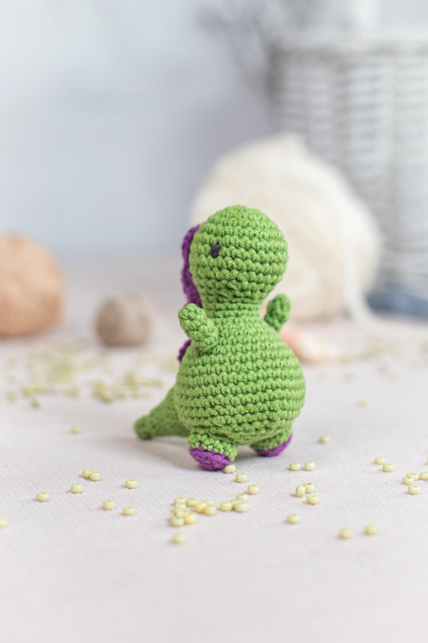 a small crocheted dinosaur sitting on a table
