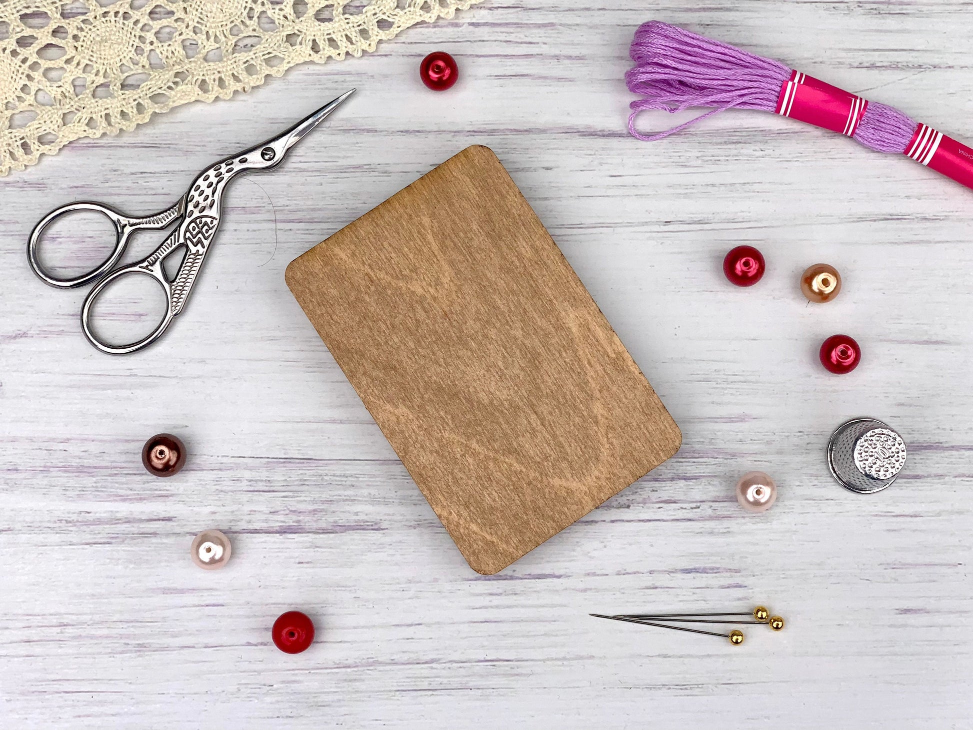 a wooden cutting board surrounded by sewing supplies