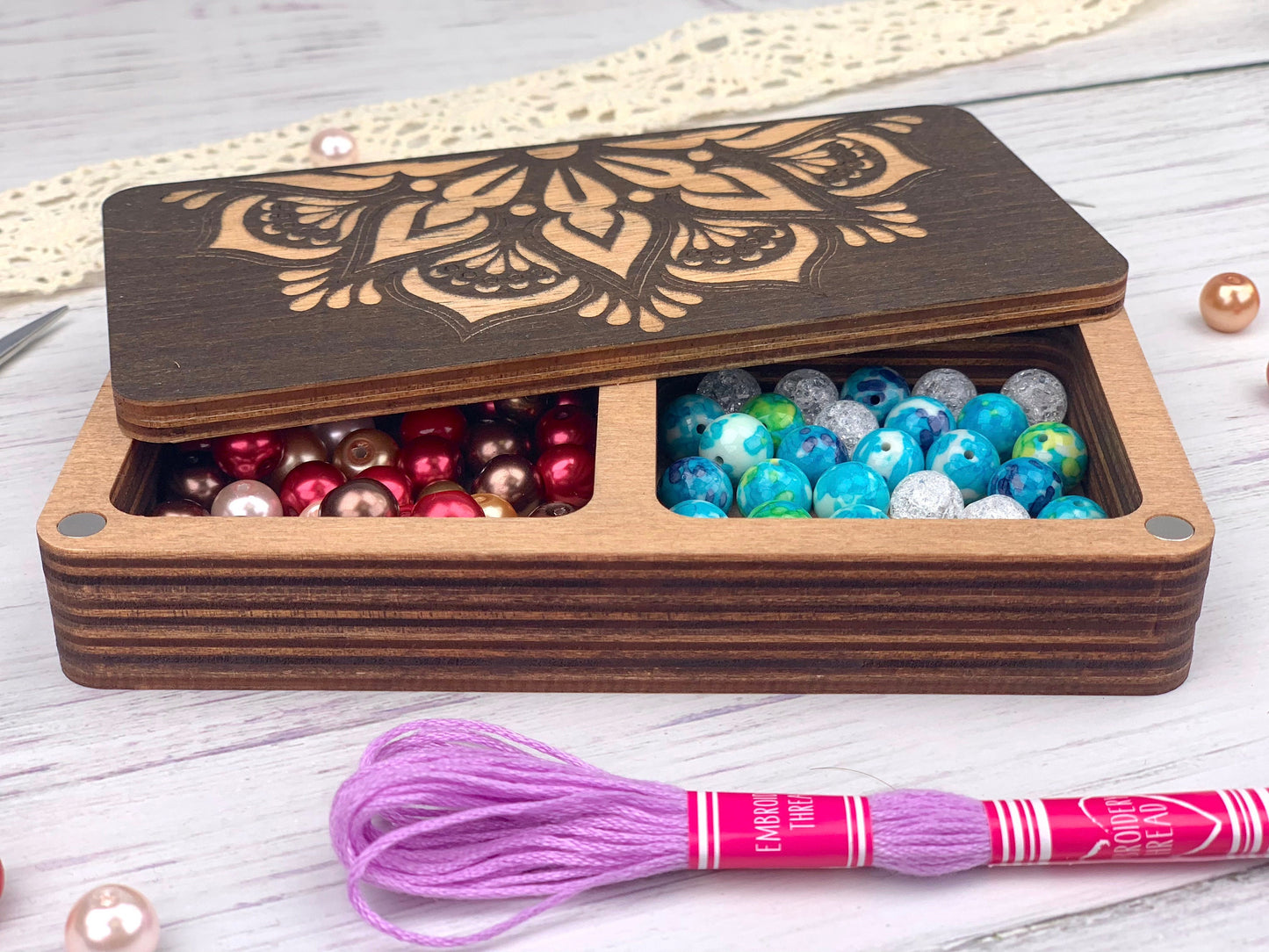 a wooden box with beads and a crochet hook
