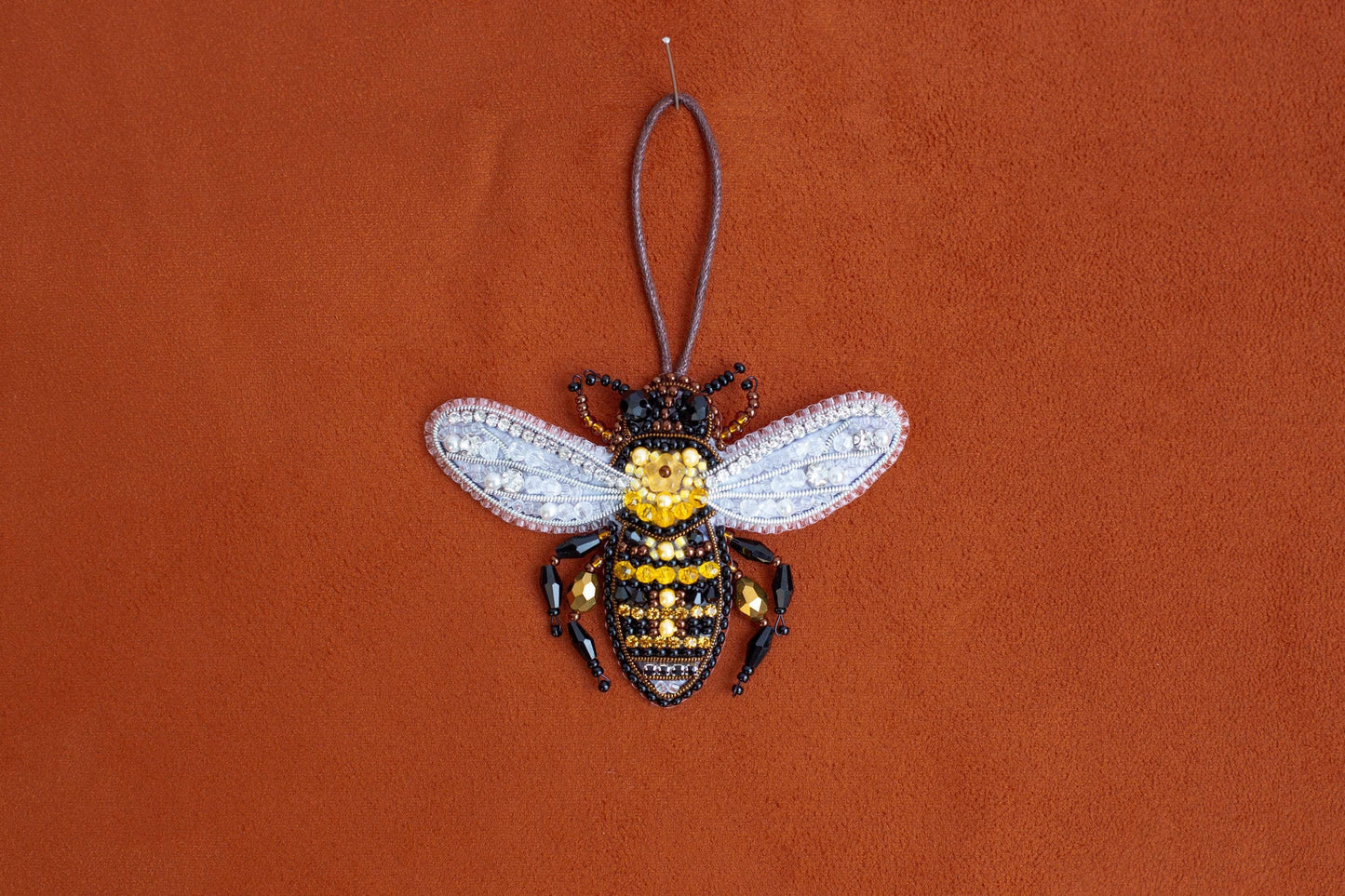 a beaded bee ornament hanging from a cord