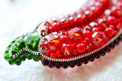 a close up of a red beaded brooch