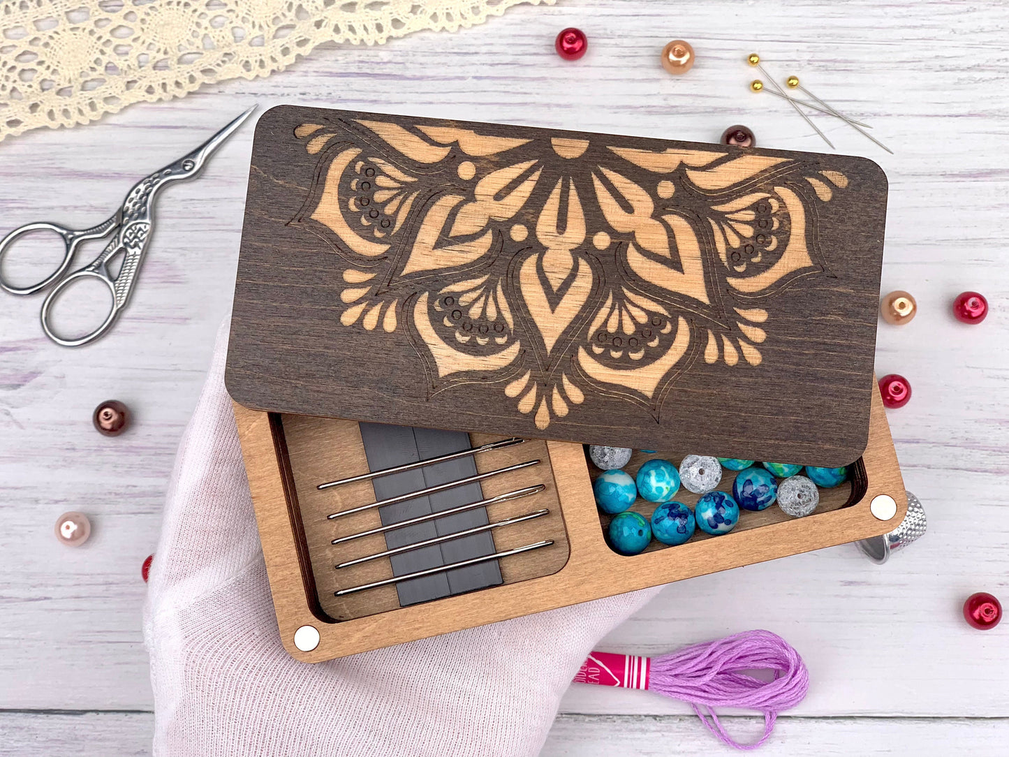 a wooden box with beads and a pair of scissors