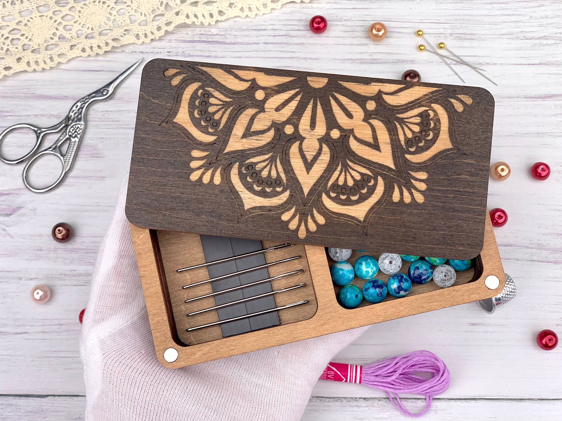 a wooden box with beads and a pair of scissors