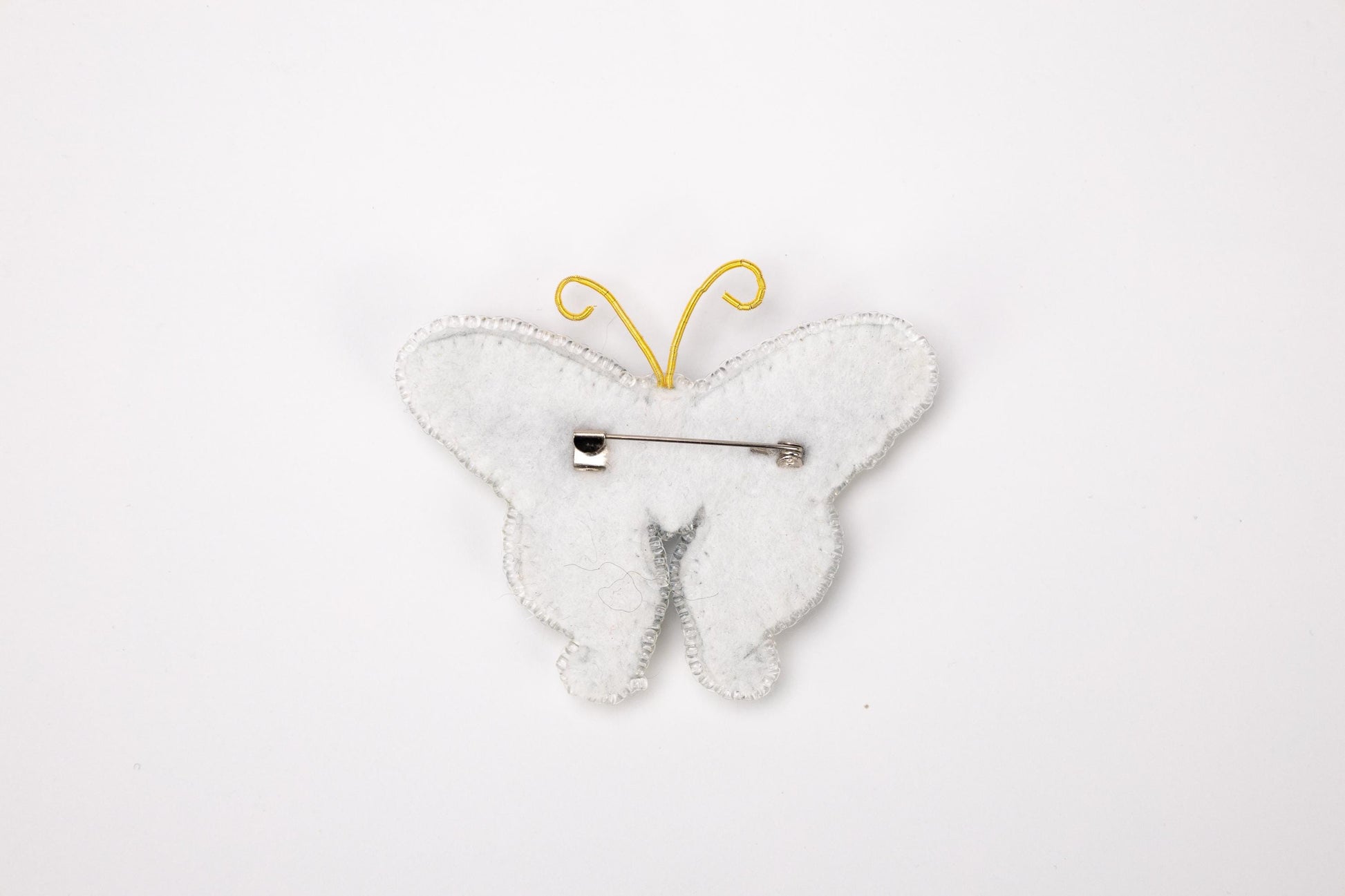 a white butterfly shaped brooch with a hair pin