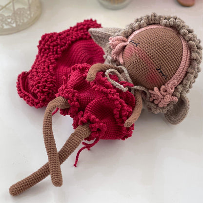 a knitted doll laying on top of a table
