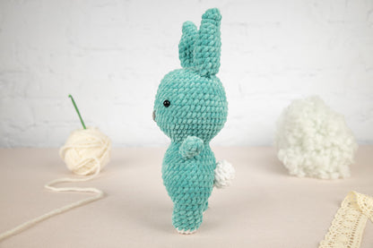 a crocheted bunny rabbit next to a ball of yarn