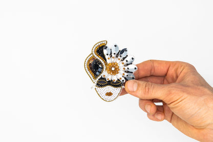 a hand holding a small decorative object in it&#39;s left hand