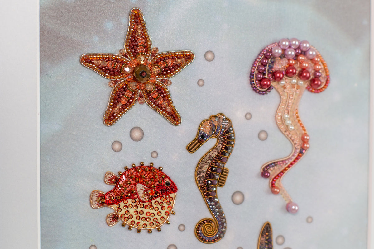 a collection of colorful, intricately designed sea creatures, including a starfish, a pufferfish, a seahorse, and a jellyfish, all adorned with sparkling embellishments.