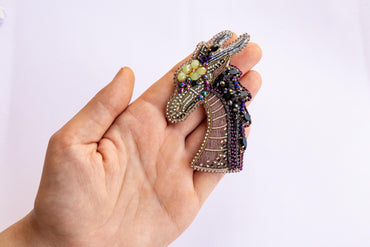 a person is holding a brooch in their hand