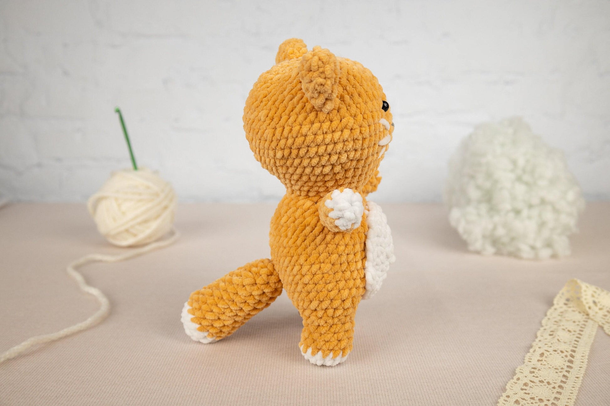 a hand holding a small crocheted cat