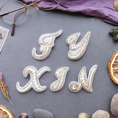 a collection of decorative elements arranged on a grey background, including a pair of glasses, a purple fabric, and various fruits and stones.