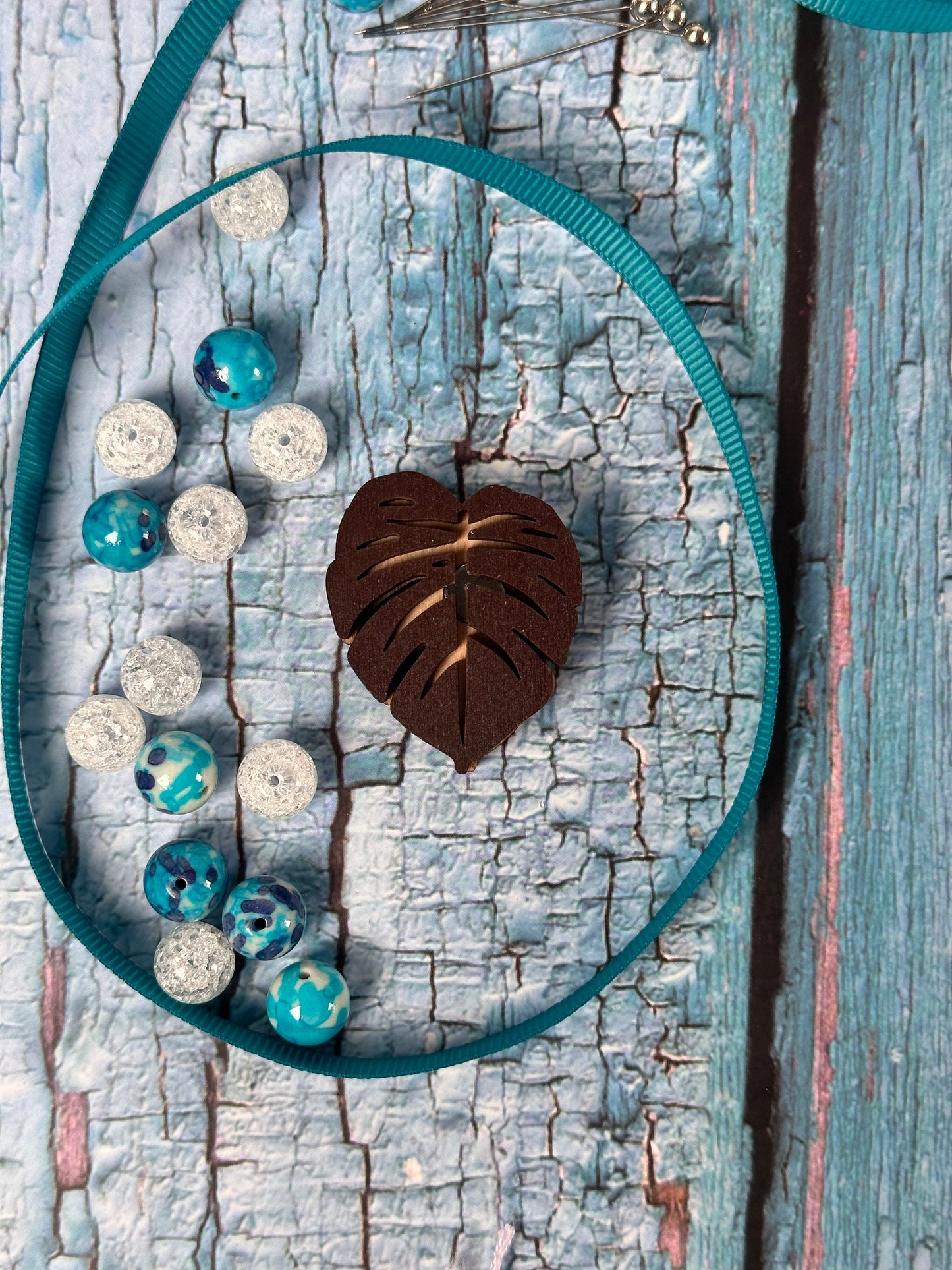 a blue and white bag with beads and a leaf on it