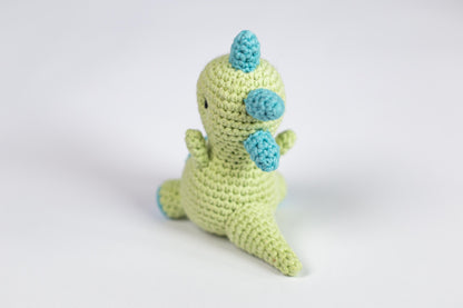 a crocheted toy of a green dinosaur